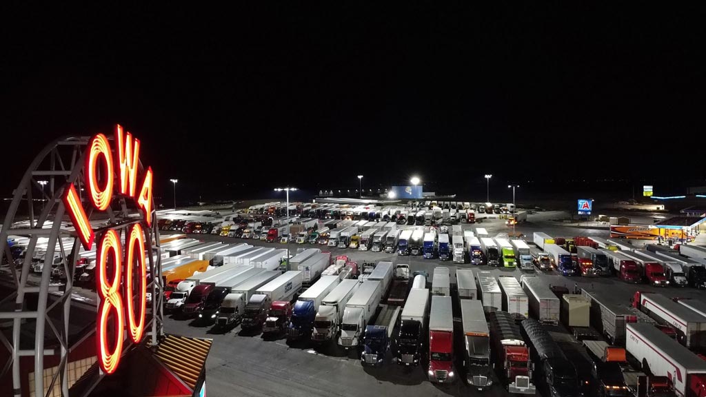 Photograph of trucks parked at Iowa 80 Truckstop at night.